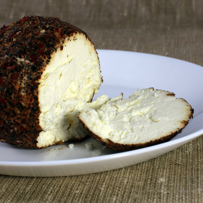 Creamy, crumbly and slightly Sour Cream Cheese is hand rolled, crusted with a blend of Black Pepper and Garlic powder and aged for 2-3 months.